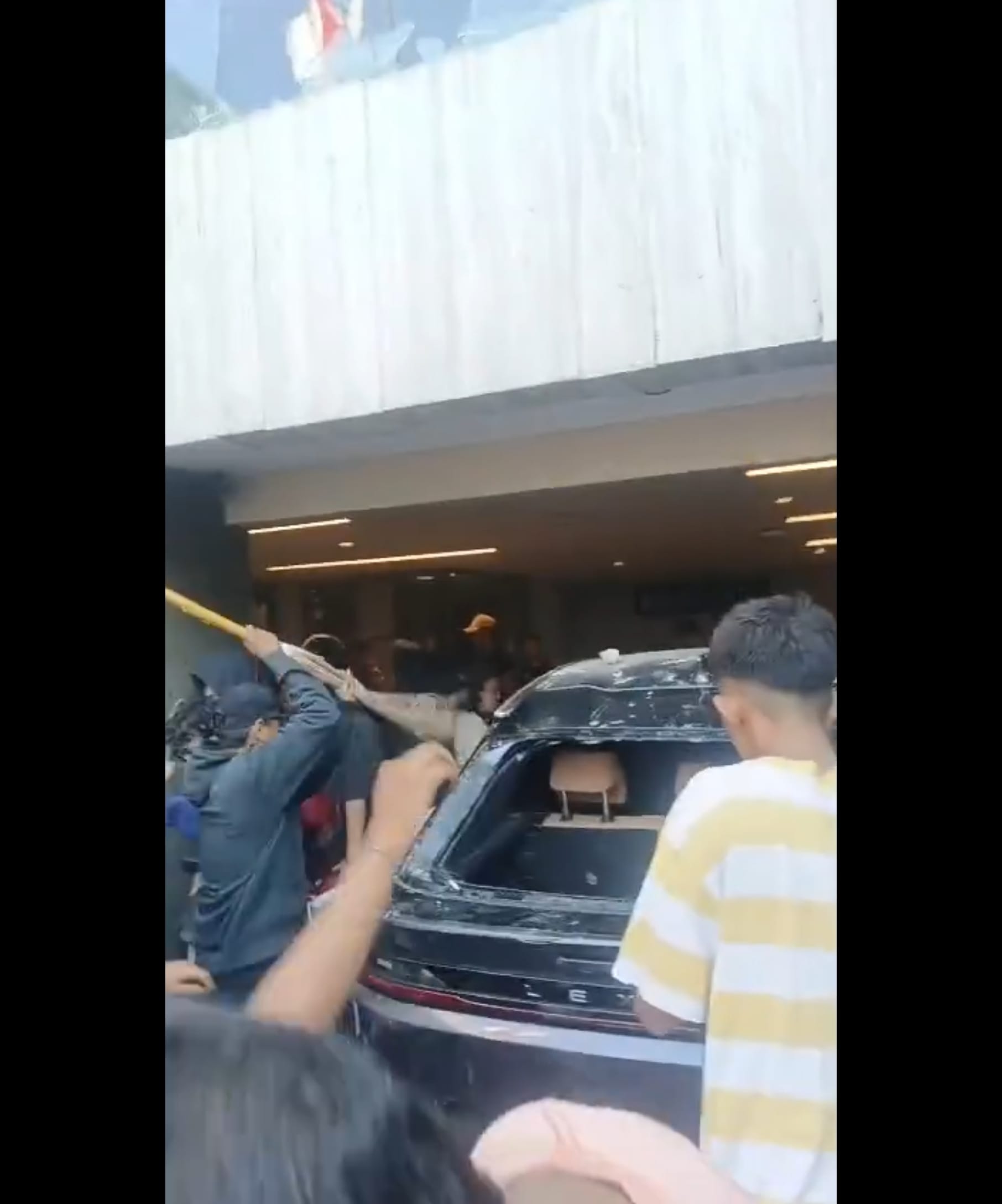 (Foto: Salah satu mobil yang berada di garasi rumah milik Ahmad Sahroni dihancurkan masa/doc)